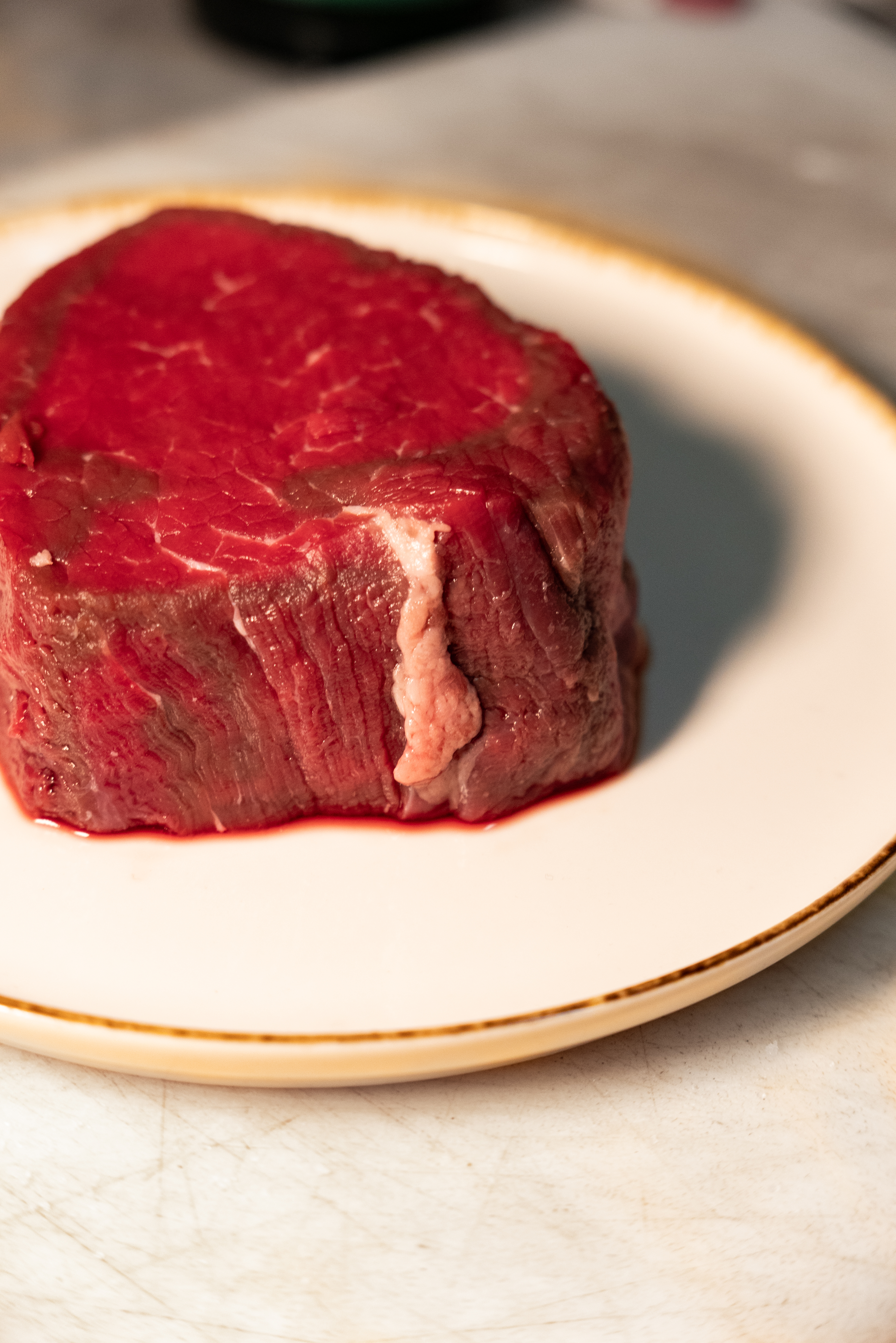 Taglio di carne cruda selezionata su piatto chiaro